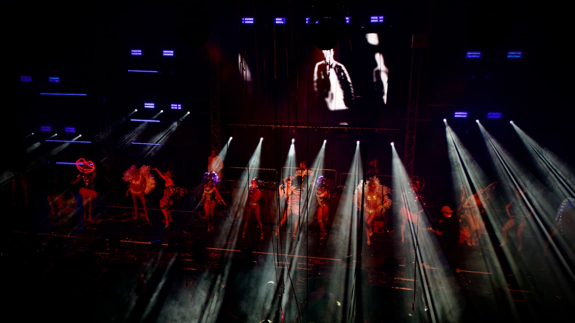 Bühnenshow mit Darstellenden und weißen Lichtstrahlen